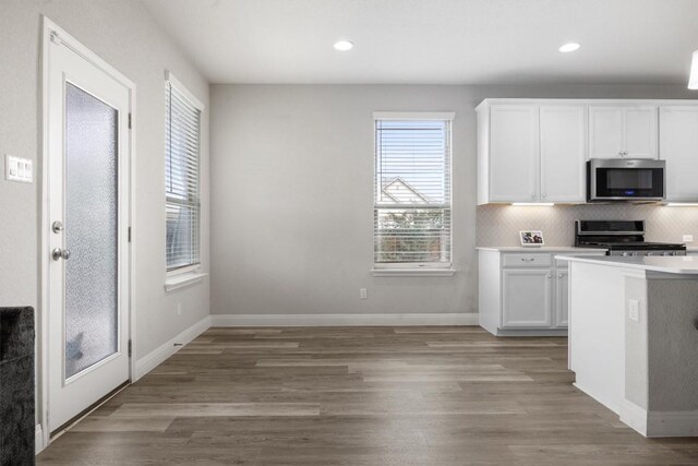 7404 Leonardo Dr, Round Rock, TX 78665 - kitchen featuring appliances with stainless steel finishes, white cabinetry, light wood-type flooring, light countertops, and recessed lighting