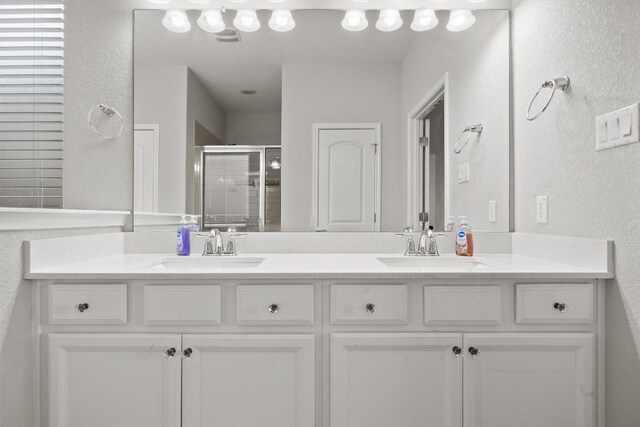 7404 Leonardo Dr, Round Rock, TX 78665 - bathroom featuring double vanity, a stall shower, and a textured wall
