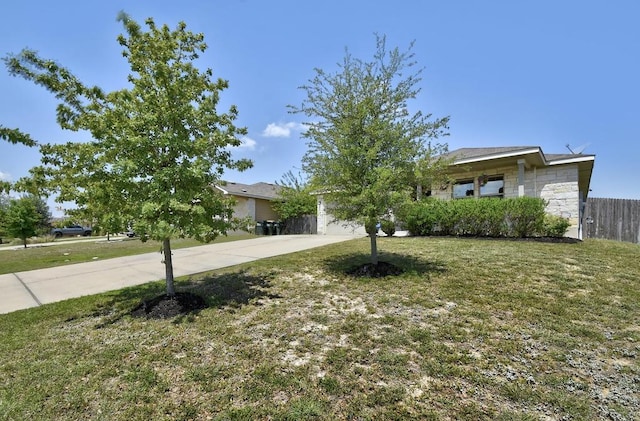 obstructed view of property featuring driveway and stone siding