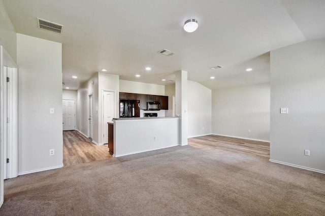 unfurnished living room featuring light carpet, recessed lighting, and baseboards