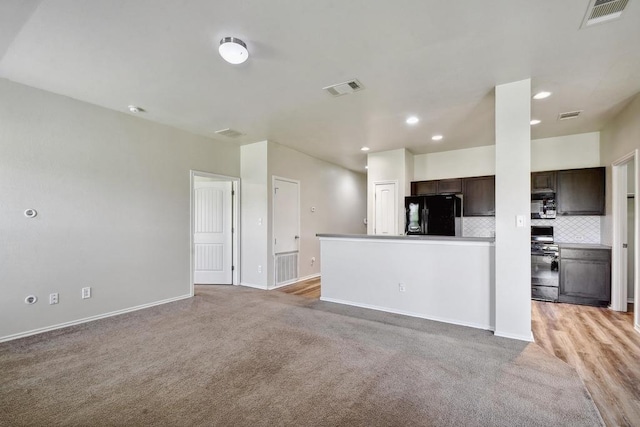 unfurnished living room featuring light colored carpet, baseboards, and recessed lighting
