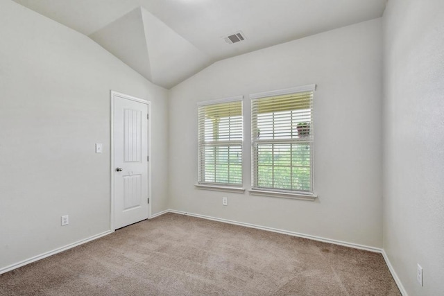 carpeted spare room with baseboards and vaulted ceiling