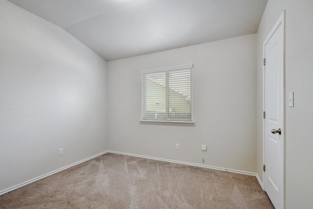 unfurnished room with carpet floors, baseboards, and vaulted ceiling