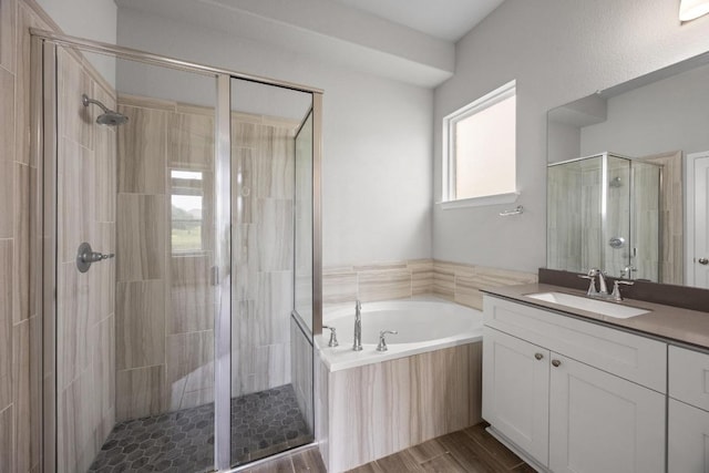257 Falling Star Ln, Georgetown, TX 78628 - full bathroom featuring vanity, a shower stall, a garden tub, and wood finished floors