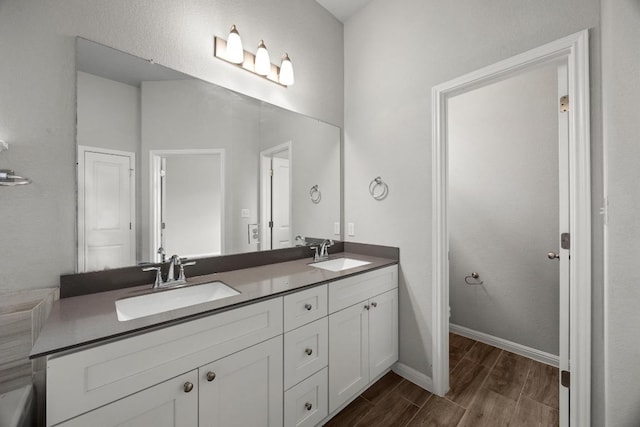 257 Falling Star Ln, Georgetown, TX 78628 - full bath featuring wood finished floors, double vanity, and baseboards