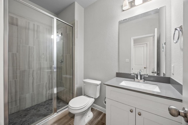 257 Falling Star Ln, Georgetown, TX 78628 - bathroom with wood finished floors, toilet, a shower stall, vanity, and a textured wall