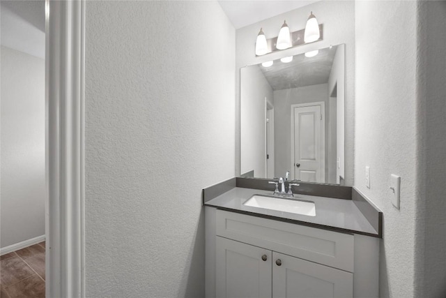 257 Falling Star Ln, Georgetown, TX 78628 - bathroom featuring vanity, a textured wall, and wood finished floors