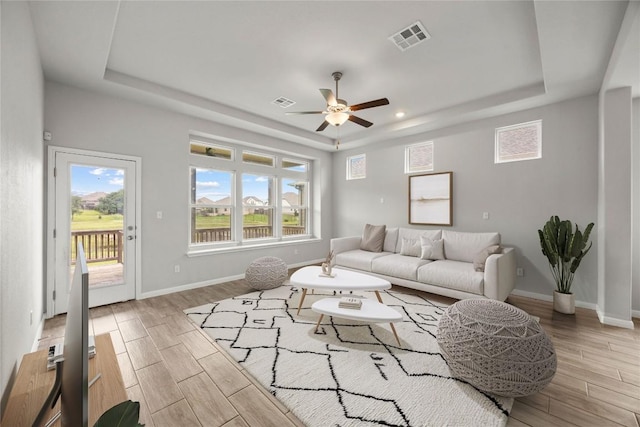 257 Falling Star Ln, Georgetown, TX 78628 - living area featuring a tray ceiling, wood finish floors, ceiling fan, baseboards, and recessed lighting