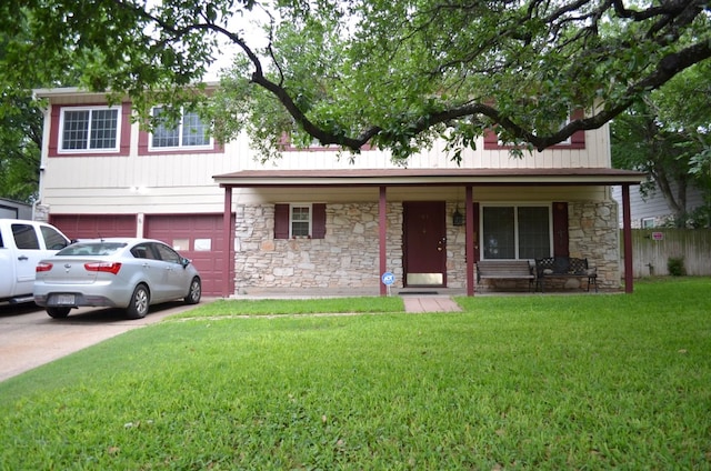 907 Pepperell Ct, Austin, TX 78753 - view of front facade featuring stone siding, a front yard, an attached garage, concrete driveway, and a porch