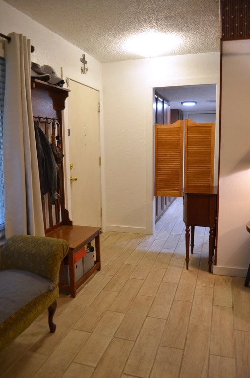 907 Pepperell Ct, Austin, TX 78753 - mudroom with wood finished floors, baseboards, and a textured ceiling