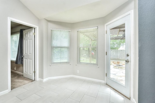 entryway with baseboards and lofted ceiling