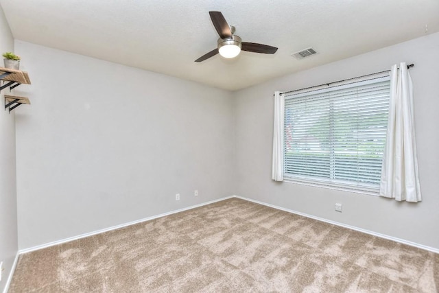 carpeted spare room with ceiling fan and baseboards