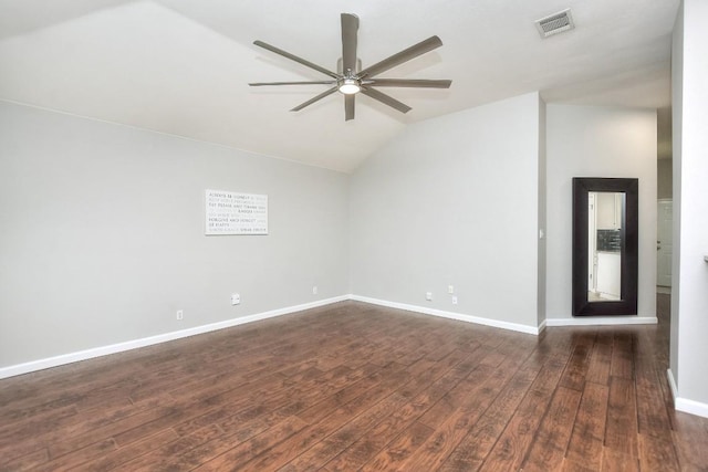 spare room featuring vaulted ceiling, a ceiling fan, dark wood-style floors, and baseboards