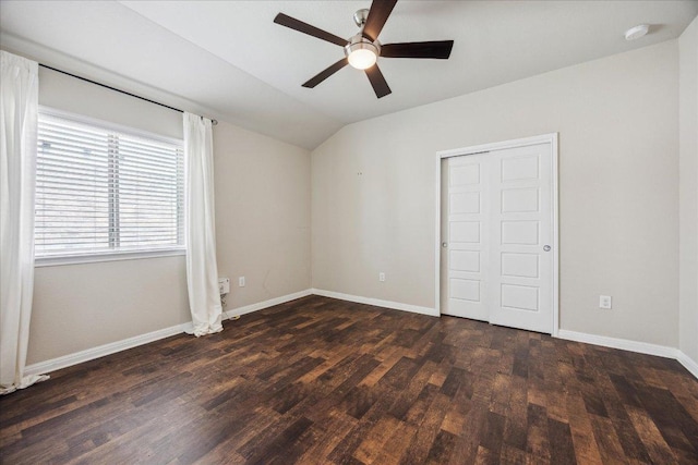 unfurnished bedroom featuring lofted ceiling, dark wood-style flooring, baseboards, and ceiling fan