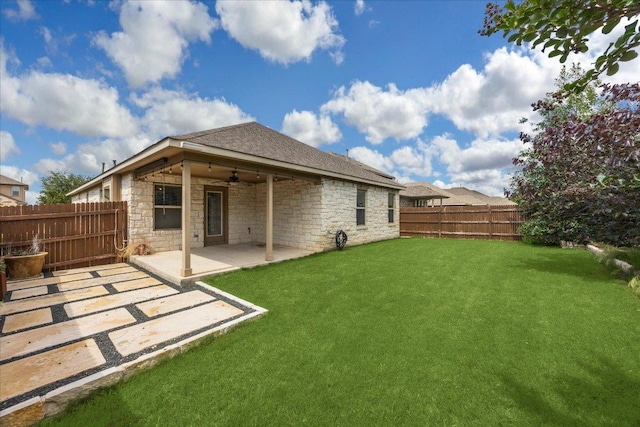 back of house with ceiling fan, a patio area, stone siding, and a shingled roof