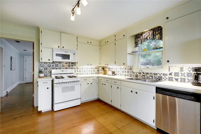 101 Short St, Smithville, TX 78957 - kitchen with white appliances, backsplash, light countertops, ornamental molding, and light wood-style floors