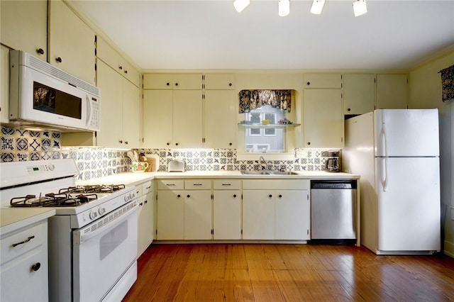101 Short St, Smithville, TX 78957 - kitchen with white appliances, cream cabinetry, backsplash, light countertops, and light wood-style flooring