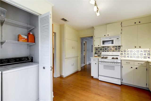 101 Short St, Smithville, TX 78957 - kitchen featuring washer / clothes dryer, white appliances, cream cabinets, and light countertops
