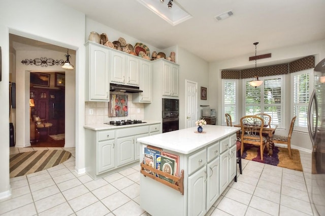 109 Cattle Trail Way, Georgetown, TX 78633 - kitchen with black appliances, under cabinet range hood, light tile patterned floors, light countertops, and a kitchen island