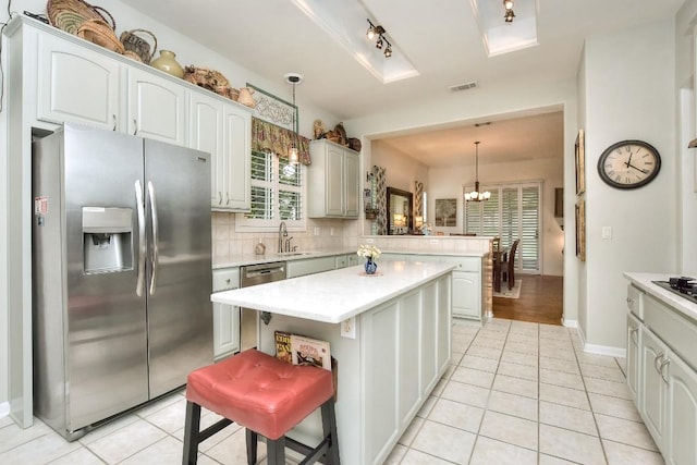 109 Cattle Trail Way, Georgetown, TX 78633 - kitchen with appliances with stainless steel finishes, a peninsula, light countertops, a chandelier, and light tile patterned floors