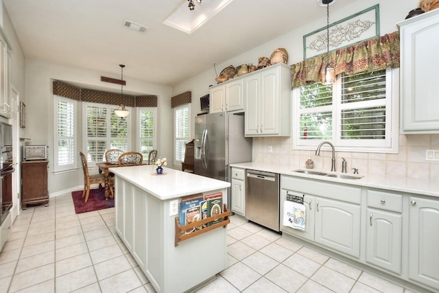 109 Cattle Trail Way, Georgetown, TX 78633 - kitchen featuring a sink, stainless steel appliances, light tile patterned floors, light countertops, and backsplash