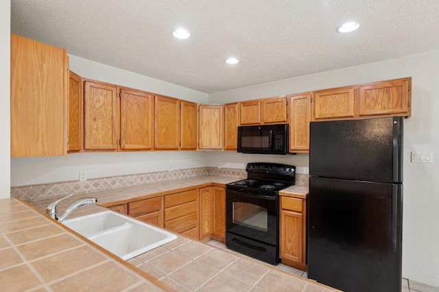 8309 Burrell Dr, Austin, TX 78757 - kitchen featuring black appliances, tile countertops, a sink, a textured ceiling, and recessed lighting