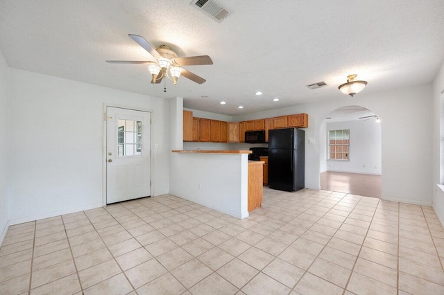 8309 Burrell Dr, Austin, TX 78757 - kitchen with black appliances, arched walkways, ceiling fan, a peninsula, and healthy amount of natural light