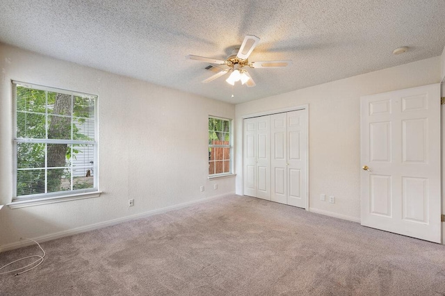 8309 Burrell Dr, Austin, TX 78757 - unfurnished bedroom featuring carpet, multiple windows, baseboards, and a textured ceiling