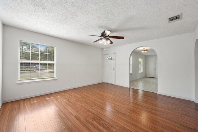 8309 Burrell Dr, Austin, TX 78757 - spare room with a ceiling fan, arched walkways, wood finished floors, a textured ceiling, and baseboards