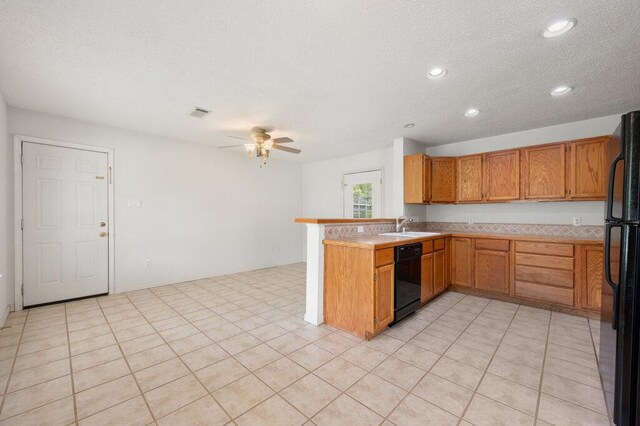 8309 Burrell Dr, Austin, TX 78757 - kitchen featuring black appliances, a peninsula, recessed lighting, a sink, and light countertops