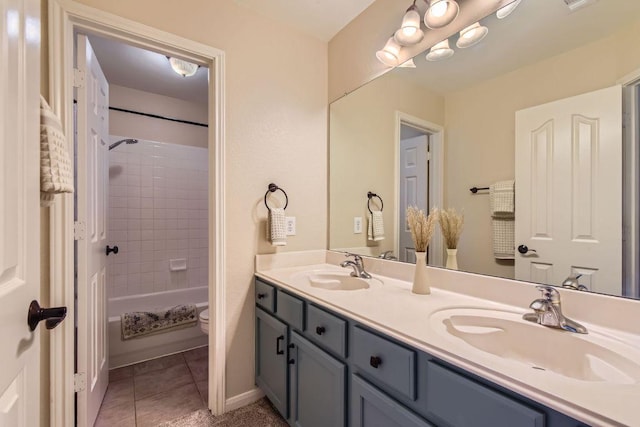 bathroom featuring double vanity, toilet, tile patterned floors, shower / tub combination, and baseboards