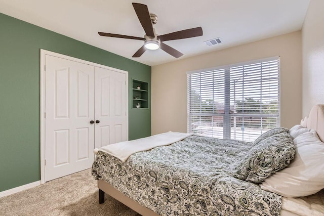 bedroom featuring multiple windows, carpet flooring, a closet, and ceiling fan