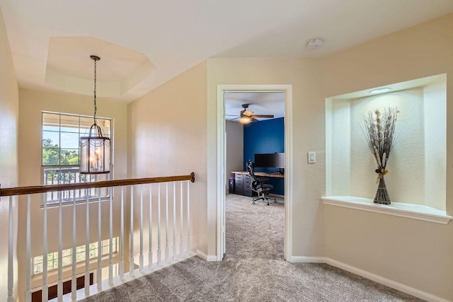 hall with carpet flooring, an office area, and baseboards