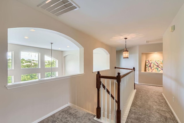 corridor with carpet flooring, baseboards, an upstairs landing, and recessed lighting