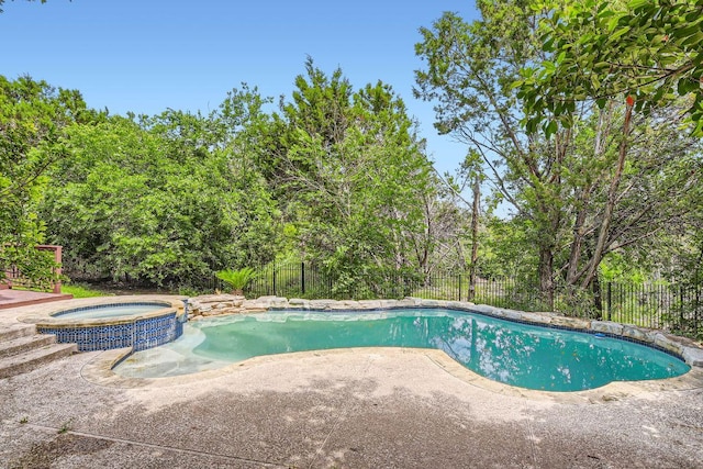 view of pool featuring a patio, a fenced backyard, and a pool with connected hot tub