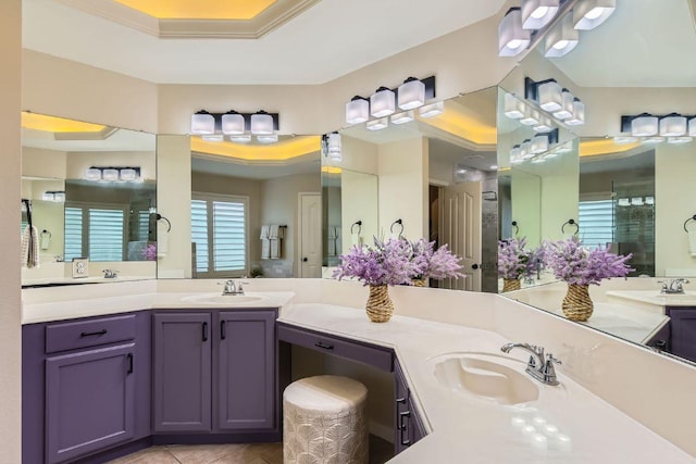 bathroom with a tray ceiling, tile patterned floors, and vanity