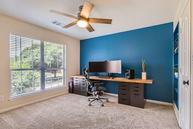 carpeted office with a ceiling fan and baseboards
