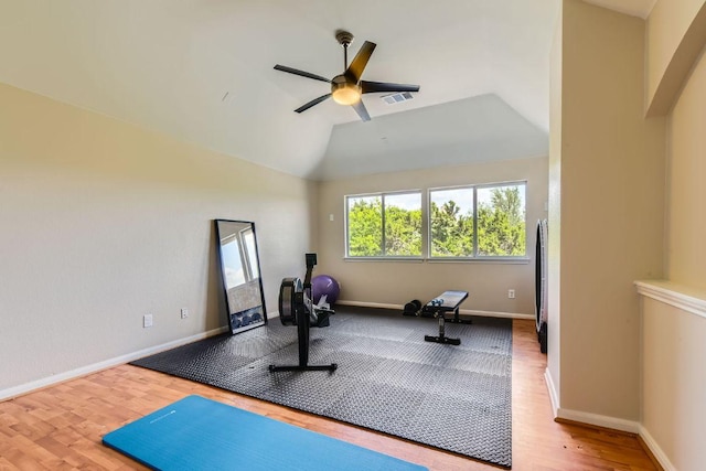 exercise area with wood finished floors, a ceiling fan, baseboards, and vaulted ceiling