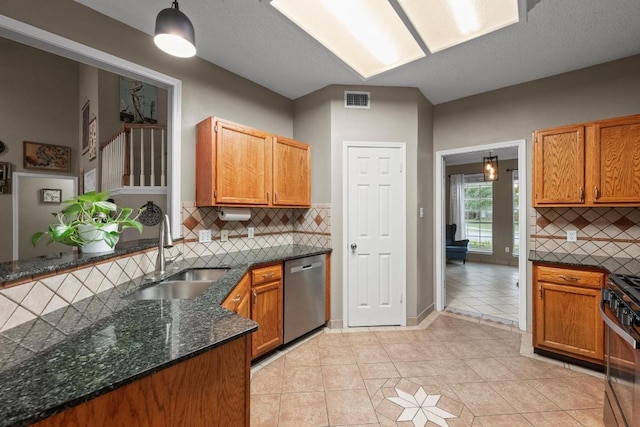 kitchen featuring a sink, appliances with stainless steel finishes, decorative backsplash, and light tile patterned flooring
