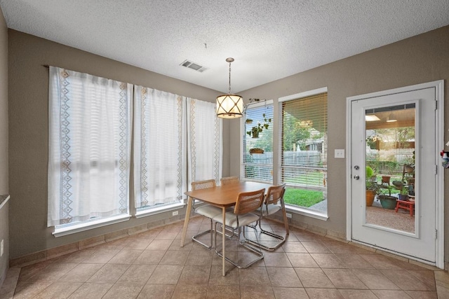 dining room with a textured ceiling and light tile patterned floors