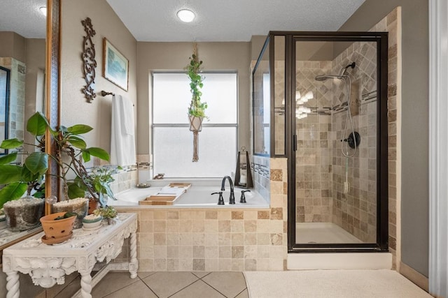 bathroom featuring a shower stall, a bath, a textured ceiling, and tile patterned flooring