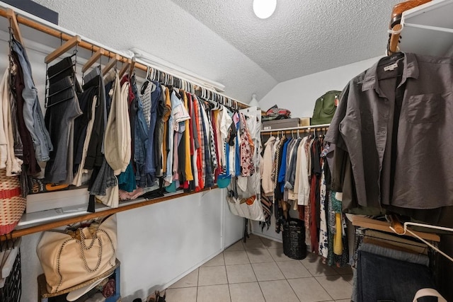 spacious closet featuring tile patterned floors and vaulted ceiling