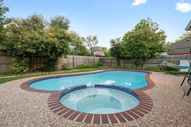 view of swimming pool with a pool with connected hot tub and a fenced backyard