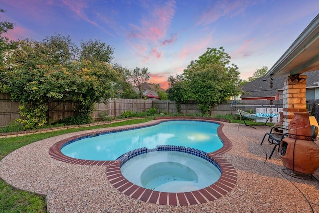 view of pool with a pool with connected hot tub, a fenced backyard, and a patio
