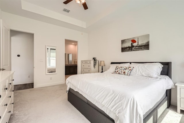 4608 Modena Bay Bnd, Leander, TX 78641 - bedroom featuring light colored carpet, a tray ceiling, ceiling fan, and connected bathroom