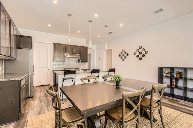 dining space with light wood finished floors and recessed lighting