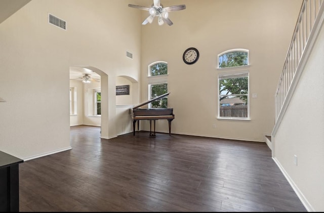 13306 James Monroe St, Manor, TX 78653 - empty room with ceiling fan, stairs, a high ceiling, and dark wood-type flooring