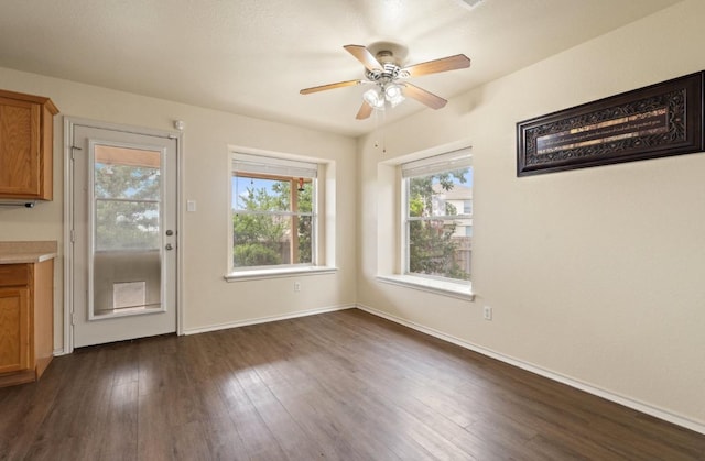 13306 James Monroe St, Manor, TX 78653 - unfurnished dining area featuring dark wood-style flooring, ceiling fan, and baseboards