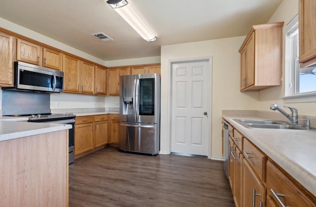 13306 James Monroe St, Manor, TX 78653 - kitchen featuring stainless steel appliances, a sink, dark wood-type flooring, and light countertops