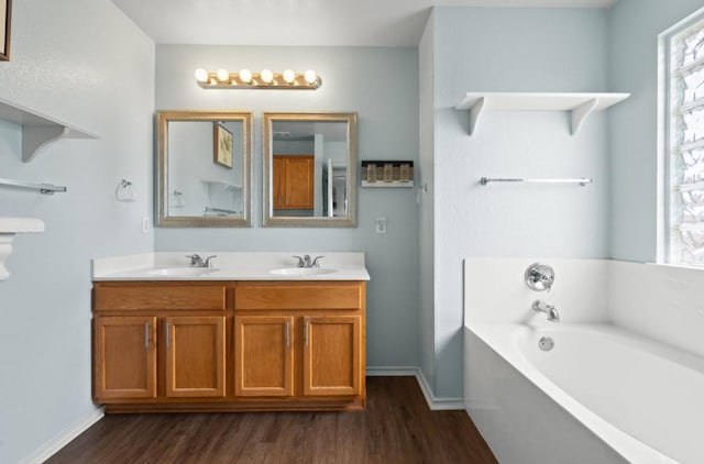 13306 James Monroe St, Manor, TX 78653 - bathroom with wood finished floors, a bath, healthy amount of natural light, and double vanity